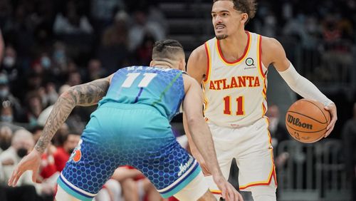 Atlanta Hawks guard Trae Young brings the ball upcourt against Charlotte Hornets forward Cody Martin during the second half of an NBA basketball game Sunday, Jan. 23, 2022, in Charlotte, N.C. (AP Photo/Rusty Jones)