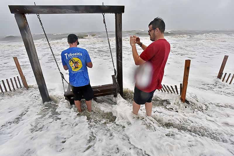 Brett Lay (left) and James Simpson take pictures in the waters off Tybee Island.