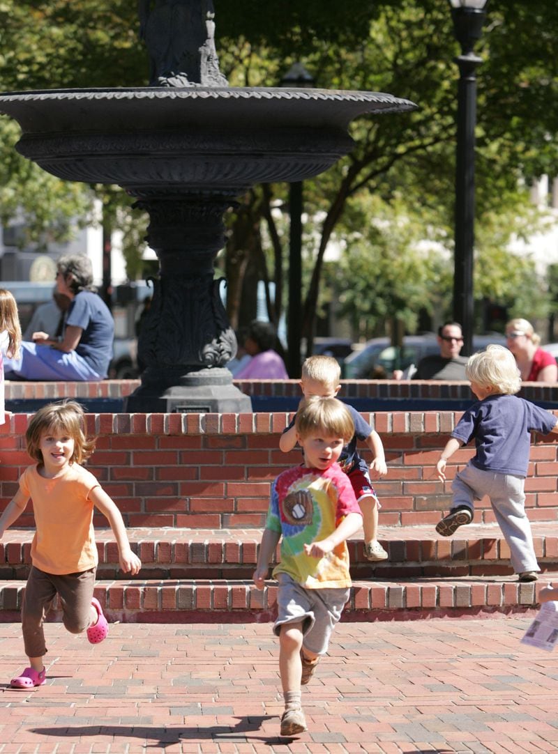 (Left to right) Ellia Kelso, 5, Dawson Hancock, age 5 (in tie-dye T-shirt), Hank Austin, 3 (behind Dawson) and Micah Hancock, 3, run around the fountain during a music performance.