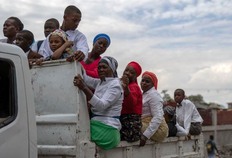 People commute on the back of a truck after attending a church service in the Petion-Ville neighborhood of Port-au-Prince, Haiti, Sunday, April 21, 2024. (AP Photo/Ramon Espinosa)