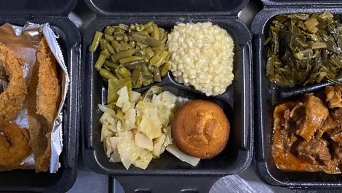 Who’s Got Soul Southern Cafe has locations in Lawrenceville and Decatur. This takeout order from the Decatur store includes a seafood platter with catfish, whiting, shrimp and hushpuppies; a vegetable plate with green beans, corn, cabbage and a corn muffin; and oxtails over rice with macaroni and cheese and collards. 
Wendell Brock for The Atlanta Journal-Constitution