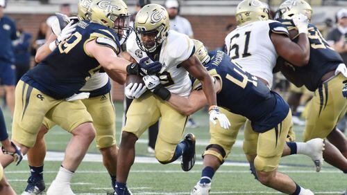Georgia Tech running back Englan Williams gets tackled by Georgia Tech defensive lineman Grey Carroll (49) and Georgia Tech linebacker Taylor McCawley (45) during the 2022 spring game. The potential for Georgia Tech athletes to earn money off their name, image and likeness is about to increase. (Hyosub Shin / Hyosub.Shin@ajc.com)