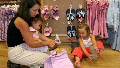Dawn Higdon helped her daughters, Ansley and Alextry on shoes at Gymboree inside Gwinnett Place Mall in this AJC file photo. Gymboree filed bankruptcy this week and plans to close up to  450 of its stores.