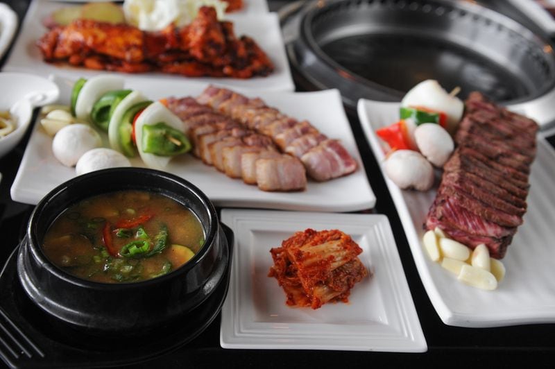 Breakers signature menu items of chicken, pork belly and short ribs, served with starters, sauces & sides including kimchi, Miso soup with spinach, rice wrap, sweet radish wrap and rice. / AJC file photo