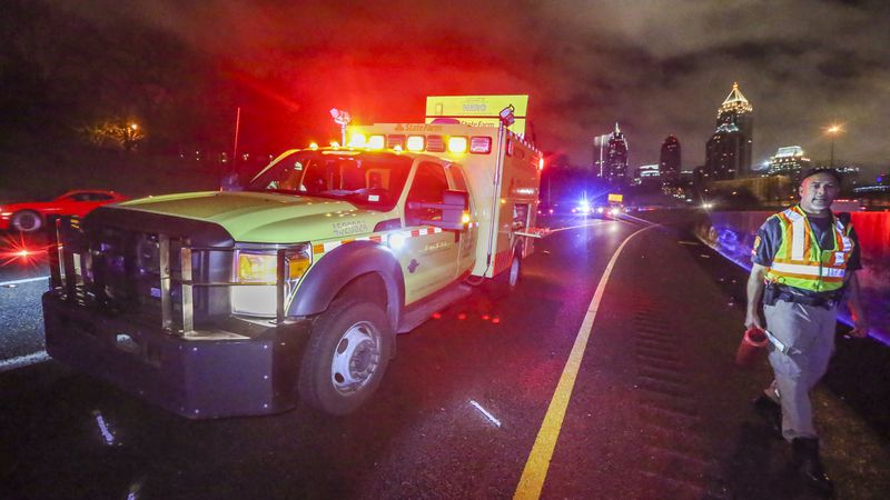 LEDE PHOTO - Dec. 24, 2015 Atlanta: GDOT HERO operator, Griff Singleton walks past the HERO truck where a Georgia Department of Transportation Highway Emergency Response Operator was hit by a pickup truck and injured while working a wreck in Midtown during Thursday's predawn storms Dec. 24, 2015. The incident happened about 4:45 a.m. on the northbound I-75 HOV ramp at the Brookwood Interchange. According to the Georgia State Patrol, HERO driver Christopher D. Seslar was putting out flares to block the roadway after an earlier wreck when he was hit by a 1998 Ford pickup truck. The pickup driver, Richard K. Hutto, 38, of Fitzgerald, apparently struck a guard rail first, then over-corrected and hit Seslar, a GSP spokesperson said in an email. Hutto, who was not injured, was charged with reckless driving, failure to maintain lane, driving too fast for conditions, driving on a suspended license, failure to exercise due care and to obey the state's "move over" law that requires drivers to move over a lane when approaching an emergency vehicle. Channel 2 Action News reported that Seslar was taken to Grady Memorial Hospital in stable condition. JOHN SPINK /JSPINK@AJC.COM