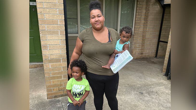 Louana Joseph with her son, M.J. (left), and her infant daughter, Marlie, outside their former apartment complex in southwestern Atlanta. Joseph moved out of the unit because she suspected the gray and brown splotches that were spreading through the unit were mold. After rents soared during the pandemic, some families were forced to live in substandard housing, which increased their risk for health problems such as asthma and lead poisoning. (Andy Miller/KHN)