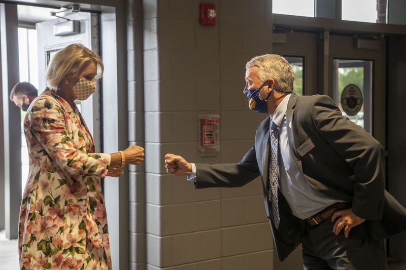 08/25/2020 - Cumming, Georgia - United States Secretary of Education Betsy DeVos (left) greets Forsyth County Schools Superintendent Jeff Bearden with a fist bump during a visit to Forsyth Central High School in Cumming, Tuesday, August 25, 2020. (ALYSSA POINTER / ALYSSA.POINTER@AJC.COM)