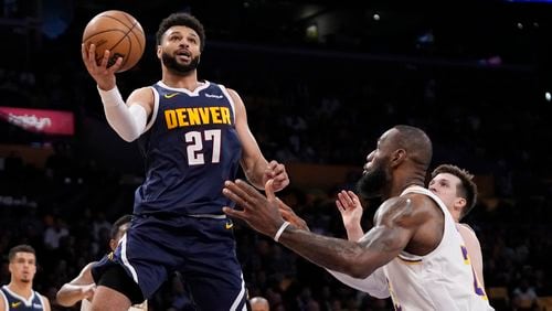 Denver Nuggets guard Jamal Murray, left, shoots as Los Angeles Lakers forward LeBron James defends during the first half in Game 4 of an NBA basketball first-round playoff series Saturday, April 27, 2024, in Los Angeles. (AP Photo/Mark J. Terrill)