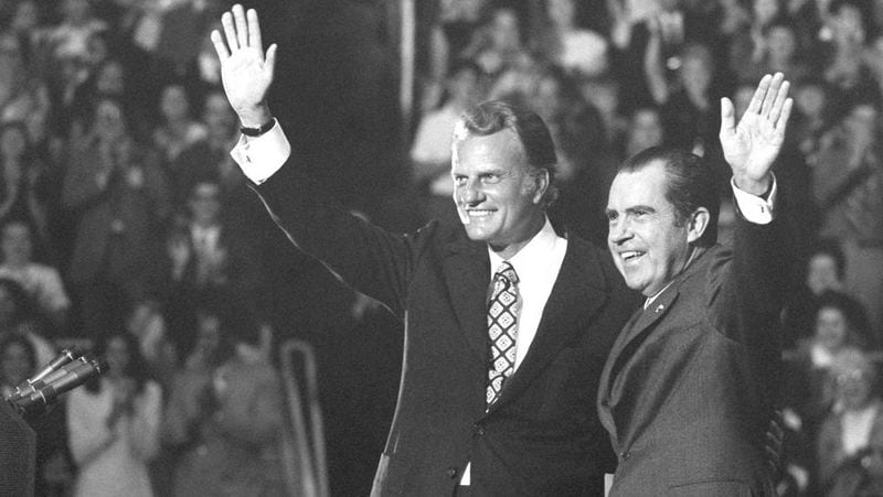 FILE - In this Oct. 16, 1971 file photo, Evangelist Billy Graham and President Nixon wave to a crowd of 12,500 at ceremonies honoring Graham at Charlotte, N.C.   Graham, who transformed American religious life through his preaching and activism, becoming a counselor to presidents and the most widely heard Christian evangelist in history, has died. Spokesman Mark DeMoss says Graham, who long suffered from cancer, pneumonia and other ailments, died at his home in North Carolina on Wednesday, Feb. 21, 2018. He was 99. (AP Photo, File)