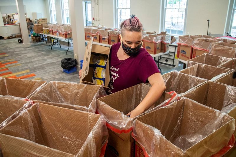 Food 4 LIFE volunteer Jessica Struempf packs up some of the 100 boxes of groceries in preparation for their delivery in Atlanta. STEVE SCHAEFER / SPECIAL TO THE AJC