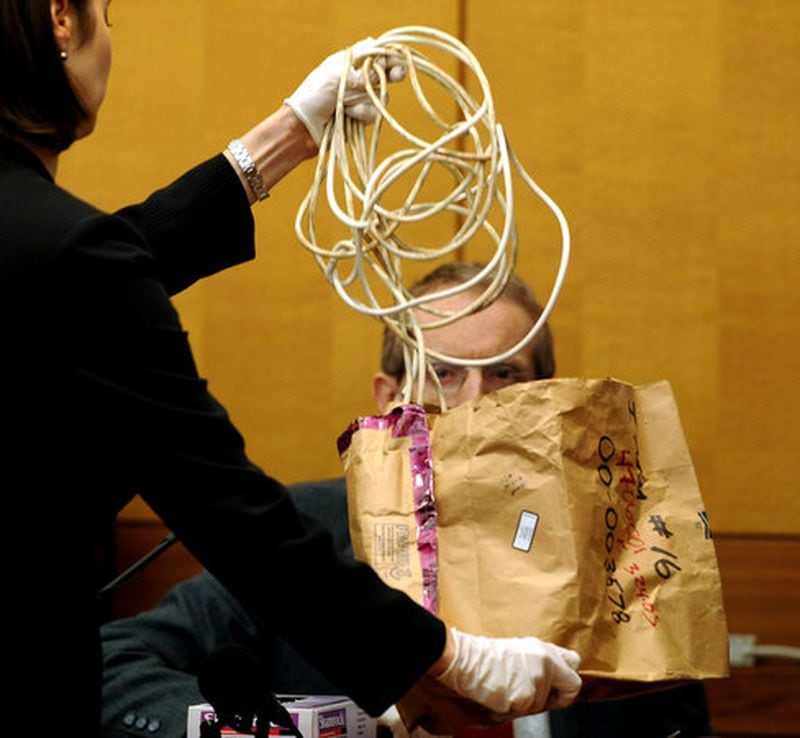 Fulton County prosecutor Sheila Ross shows an electrical cord from a vacuum cleaner to Dr. Michael Henniger of the Fulton County Medical Examiners office during the 2008 murder trial of Chiman Rai. The cord was one of the items used in the death of Sparkle Reid Rai, prosecutors said.