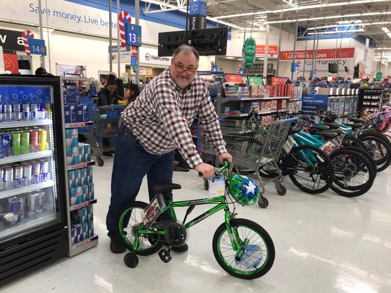  Tony Nix of Duluth awaits his partner, who is finishing shopping for an eight-year-old in Catoosa County. This is at least his fifth year doing this. CREDIT: Rodney Ho/rho@ajc.com