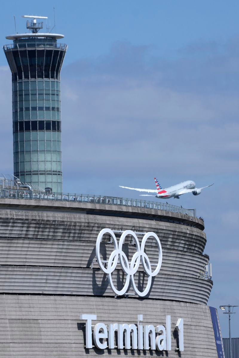 A plane takes off from Charles de Gaulle airport where the olympic rings were installed on terminal 1, in Roissy-en-France, north of Paris, Tuesday, April 23, 2024 in Paris. (AP Photo/Thibault Camus)