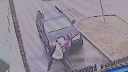 A gas station surveillance camera shows a woman fighting off another woman before three men pick up her dropped keys and drive away in her car. (Credit: Channel 2 Action News)