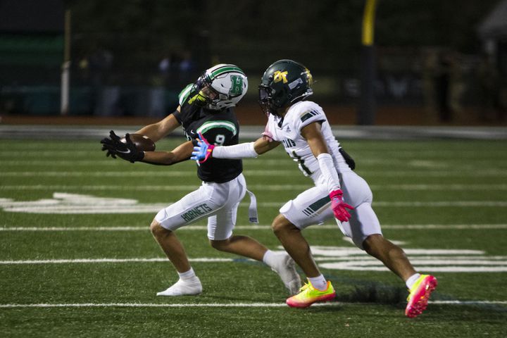 Hill Plunkett, corner back for Roswell, intercepts the ball from Zyon Mckenzie, wide receiver for Blessed Trinity,  during the Blessed Trinity vs. Roswell high school football game on Thursday, September 29, 2022, at Roswell high school in Roswell, Georgia. Roswell led Blessed Trinity 34-0 at the end of the third quarter. CHRISTINA MATACOTTA FOR THE ATLANTA JOURNAL-CONSTITUTION.