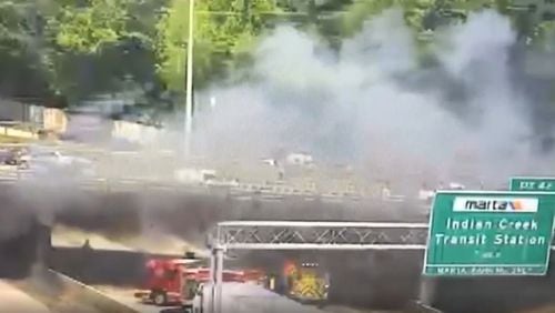 A tractor-trailer carrying cars stopped under a bridge on I-285 after one of the cars in its payload caught on fire, raising fears that the blaze might have damaged the bridge.