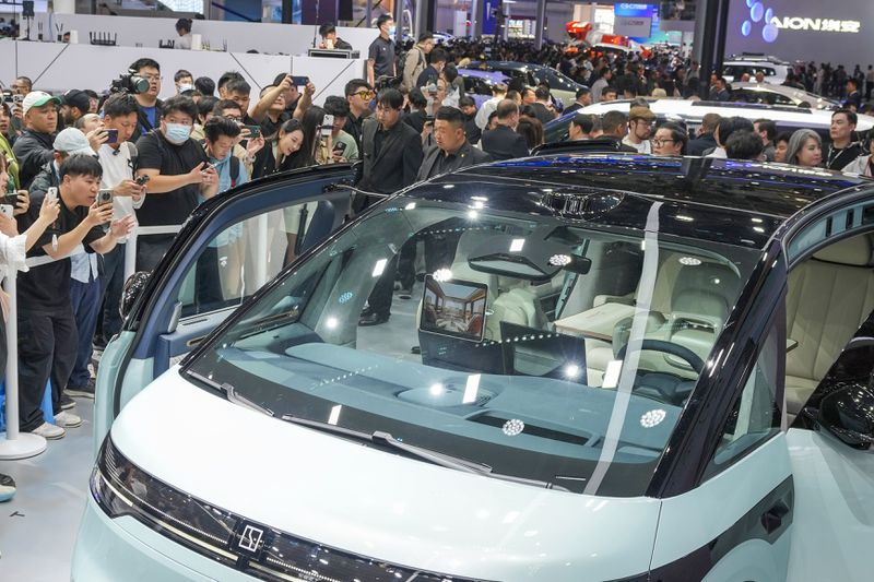 Visitors take photos of a Zeekr car during the opening of China Auto Show in Beijing, China, Thursday, April 25, 2024. (AP Photo/Tatan Syuflana)