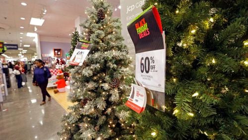 A shopper walks past a display of artificial Christmas trees at a JCPenney store Friday, Nov. 24, 2017, in Seattle. Black Friday has morphed from a single day when people got up early to score doorbusters into a whole season of deals, so shoppers may feel less need to be out. (AP Photo/Elaine Thompson)