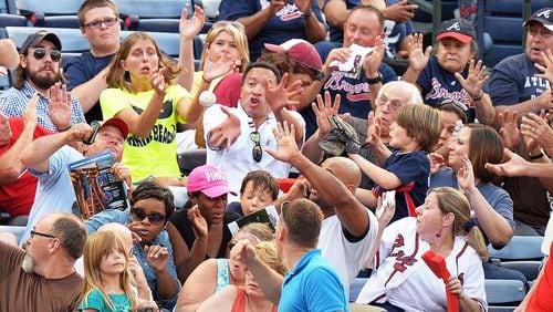 Fans react to a foul ball hit into the stands during a 2014 game at Turner Field. (BRANT SANDERLIN /BSANDERLIN@AJC.COM)