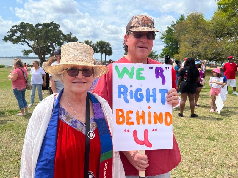 The Rev. Jane Page (left) and Georgia Southern University professor Greg Brock hold up a sign at the rally on Saturday afternoon in coastal Georgia.