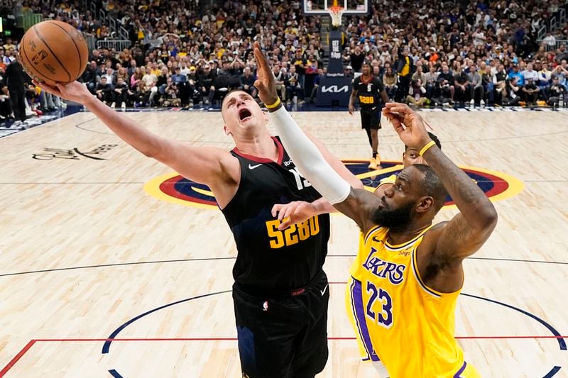 Denver Nuggets center Nikola Jokic (15) goes up for a short against Los Angeles Lakers forward LeBron James (23) during the second half in Game 2 of an NBA basketball first-round playoff series, Monday, April 22, 2024, in Denver. (AP Photo/Jack Dempsey)