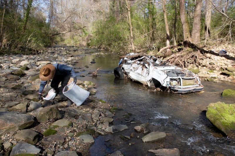 Volunteer Rhett Rutherford bagged trash along Proctor Creek during Sweep The Hooch day in Atlanta in March of 2021. Proctor Creek runs through Atlanta and ultimately empties into the Chattahoochee River. STEVE SCHAEFER FOR THE ATLANTA JOURNAL-CONSTITUTION