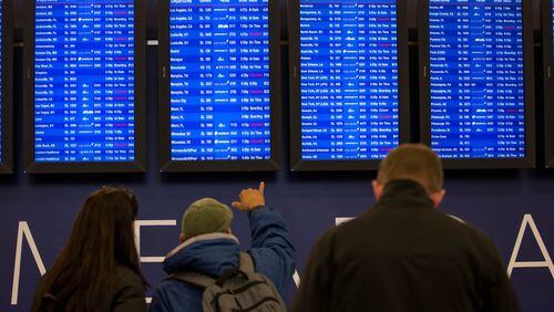 Travelers monitor the boards at Hartsfield-Jackson Atlanta International Airport, Friday, Jan. 6, 2017, in Atlanta. Delta canceled about 350 flights due to inclement weather. BRANDEN CAMP/SPECIAL