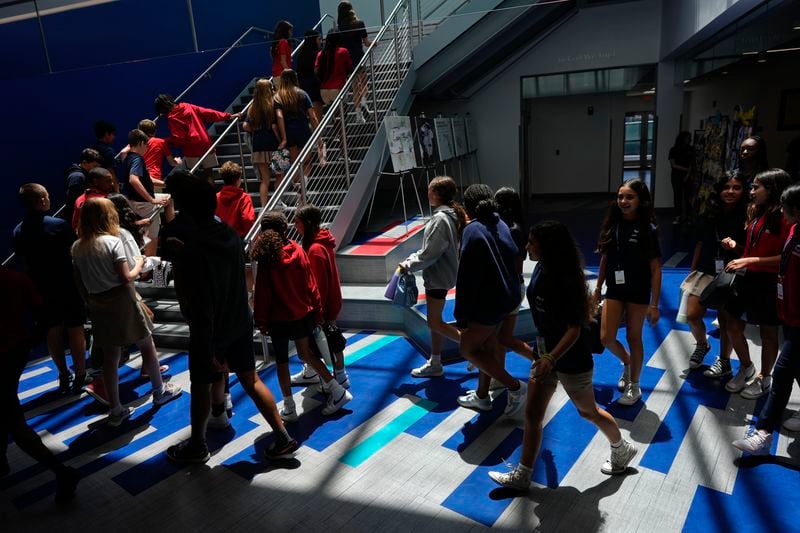 Middle school students walk between classes at A.D. Henderson School in Boca Raton, Fla., Tuesday, April 16, 2024. When teachers at the K-8 public school, one of the top-performing schools in Florida, are asked how they succeed, one answer is universal: They have autonomy. (AP Photo/Rebecca Blackwell)