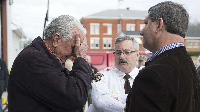 Locust Grove Mayor Robert Price (left) reacts to one of his officers being killed as he talks to Henry Chief Deputy David Foster (center) and Henry County Sheriff Keith McBrayer after a news conference Friday. (Credit: Phil Skinner)