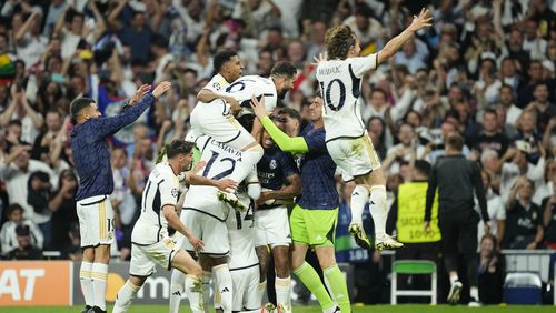 Real Madrid's Joselu, covered by his teammates, celebrates after scoring his side's second goal during the Champions League semifinal second leg soccer match between Real Madrid and Bayern Munich at the Santiago Bernabeu stadium in Madrid, Spain, Wednesday, May 8, 2024. (AP Photo/Jose Breton)