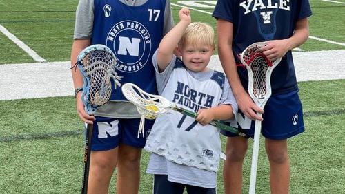 Watson and Max Howey stand with Grayson Carvel, right, the 13-year-old who created Giving with LAX, an effort to get special needs kids involved in lacrosse. Courtesy of Lindsey Carvel