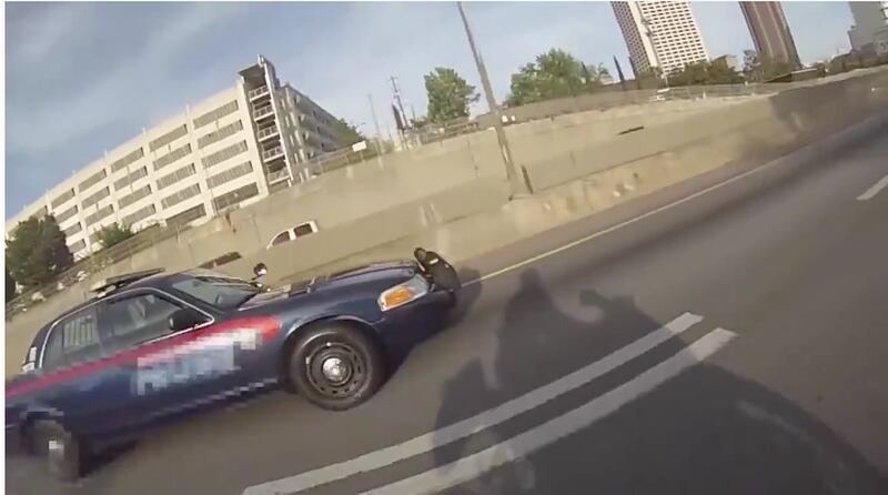 This still image shows the shadow of the motorcyclist and a pursuing Atlanta police officer. The motorcyclist sped off and weaved through traffic, leaving the officer in the dust.