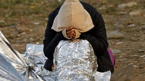 Migrants at the border between San Diego and Tijuana keep warm using Mylar blankets at night. Some have been camped there for days waiting for Border Patrol agents to pick them up and take them to be processed. (Carolyn Cole/Los Angeles Times/TNS)
