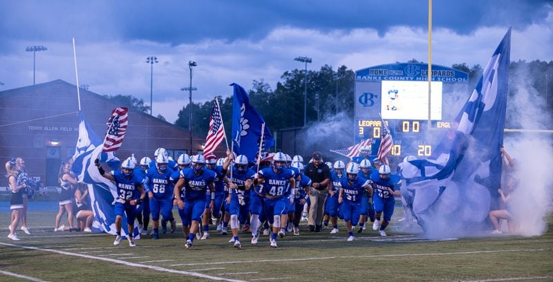 Homer -- The Banks County High School football team takes the field carrying American flags before the beginning of their September game against East Jefferson. Ben Gray for the Atlanta Journal-Constitution