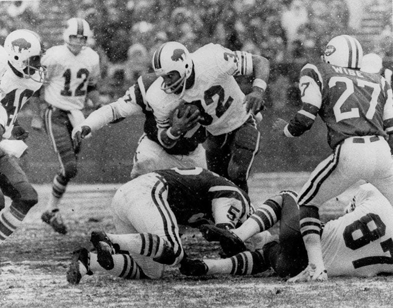 1973: O.J. Simpson of the Buffalo Bills (32) goes through the New York Jets line Dec.16, 1973 at Shea Stadium in New York in the first quarter play in which Simpson broke the NFL season rushing record. Also shown are Joe Ferguson (12) and Paul Seymour (87) of the Bills and Phil Wise (27) and John Ebersole (55) of the Jets.