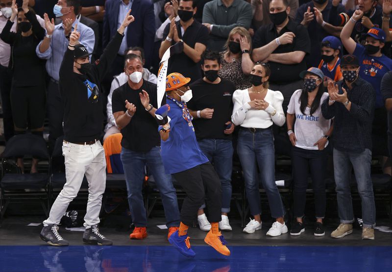 Spike Lee, in orange hat, celebrates late in the fourth quarter of Game 2 in an NBA basketball first-round playoff series between the Atlanta Hawks and the New York Knicks on Wednesday, May 26, 2021, in New York. (Elsa/Pool Photo via AP)