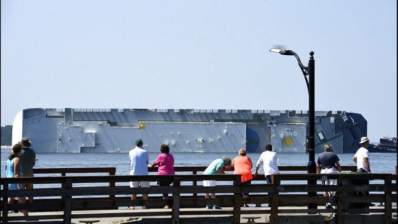 People look at a capsized cargo ship off the St. Simons Island Pier Sunday, Sept. 8, 2019.