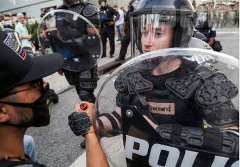 A protester offers a hand of solidarity to a policeman during Monday’s demonstrations.