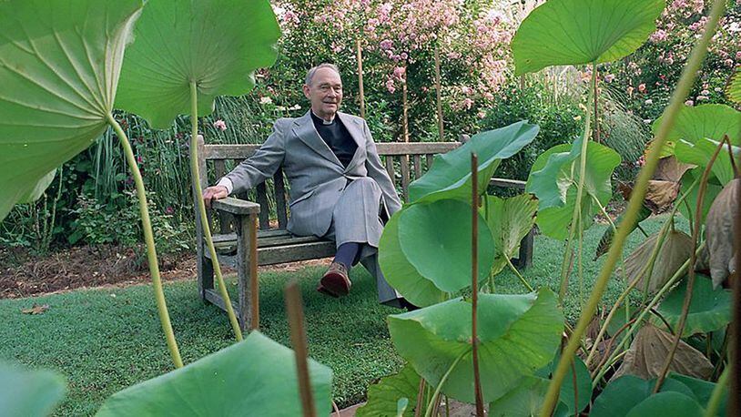 The Rev. Austin Ford, sits outside surrounded by plants in the garden of Emmaus House. (AJC file photo)