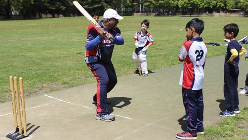 Parmanand Sarju, founder of the Long Island Youth Cricket Academy, instructs players during practice at Eisenhower Park in East Meadow, N.Y. on Saturday, May 11, 2024. " A temporary stadium for next month's T20 Cricket World Cup -- the first major international cricket competition the U.S. is hosting -- is being built atop another ball field in the park where Sarju's academy began more than a decade ago. (AP Photo/Phil Marcelo)