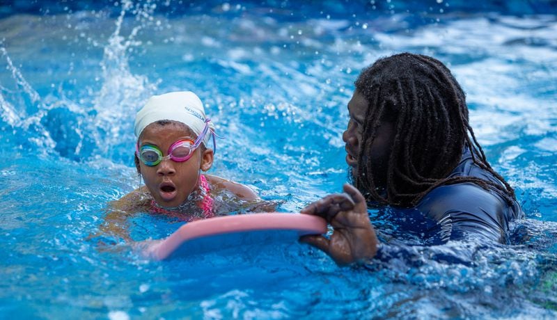 SwemKids instructor Brandon Turner(right) helps Sanya Mincey (age 7, CQ according to organizer). After COVID shuttered pools, a Fayetteville man offered his backyard pool for swimming instruction & water safety lessons to Atlanta city kids. SwemKids is a nonprofit that offers free swimming gear & lessons as an in-school program for kids in low income neighborhoods.  PHIL SKINNER FOR THE ATLANTA JOURNAL-CONSTITUTION.