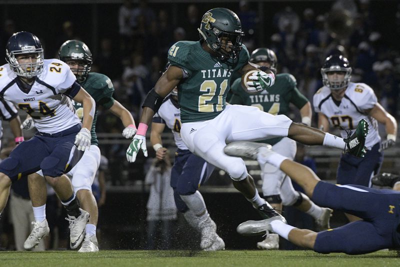 Blessed Trinity RB Elijah Green (21) is upended by a Marist defender during a high school football game, Friday, Oct. 20, 2017, in Roswell. (John Amis)