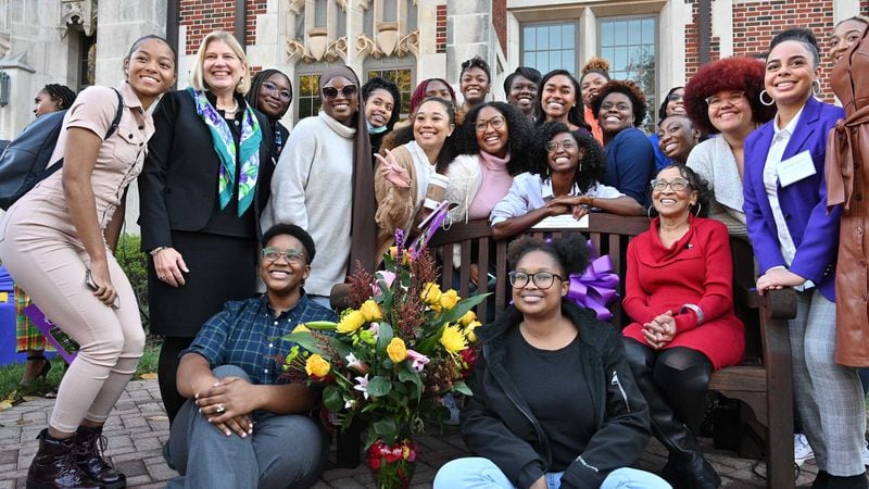 Edna Lowe Swift, dressed in red, is surrounded by Agnes Scott College students, graduates and officials after a ceremony on Nov. 17, 2021 to celebrate the 50th anniversary as the school's first Black graduate. The college placed a bench on its campus with a plaque commemorating Swift's role in its history. (Hyosub Shin / hyosub.shin@ajc.com)