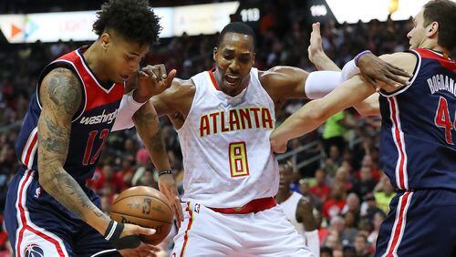 Hawks center Dwight Howard battles Wizards forward Kelly Oubre Jr. and Bojan Bogdanovic under the basket in Game 3 of a first-round NBA playoff series Saturday, April 22, 2017, in Atlanta. (Curtis Compton/ccompton@ajc.com)
