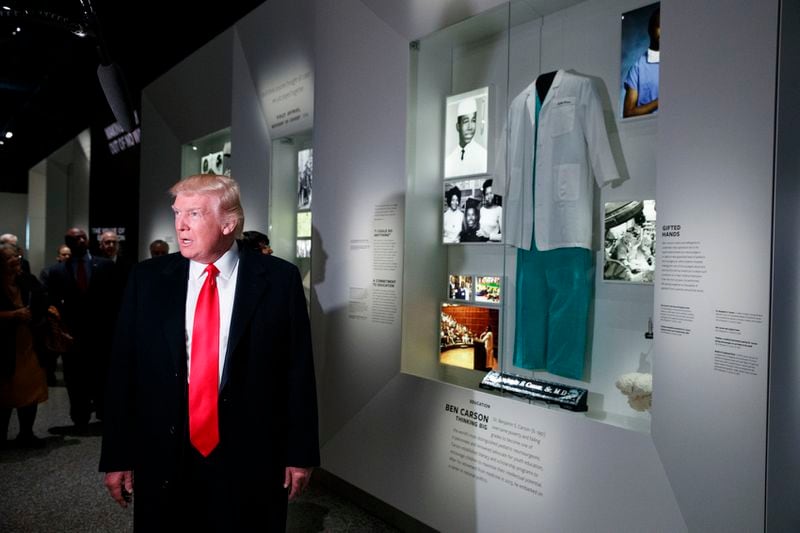 President Donald Trump talks with reporters as he stops at the exhibit for Dr. Ben Carson, his nominee for Housing and Urban Development secretary, during a tour of the National Museum of African American History and Culture, Tuesday, Feb. 21, 2017, in Washington. (AP Photo/Evan Vucci)