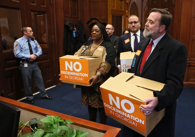 Jeff Graham, right, executive director of Georgia Equality, leads supporters carrying boxes of postcards into then-Gov. Nathan Deal’s office on March 2, 2016. Representatives from gay rights groups delivered copies of 75,000 emails to state leaders urging them to defeat so-called religious liberty legislation they believed would legalize discrimination. BOB ANDRES / BANDRES@AJC.COM