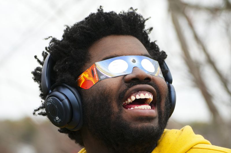 Didier Timothy-Mondesir watches the solar eclipse from Prince Edward County, Ontario, Monday, April 8, 2024. (Sean Kilpatrick/The Canadian Press via AP)