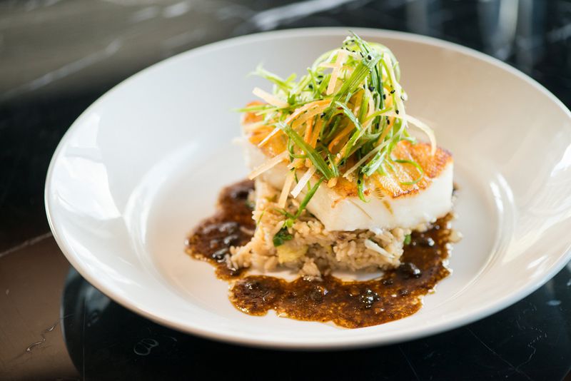 Seared Chilean Sea Bass with crab fried rice and black bean garlic sauce. Photo credit- Mia Yakel.