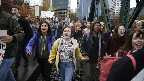 In this Nov. 14, 2016, file photo, Portland Public School students walk out of schools and converge on Pioneer Courthouse Square for a protest against the results of last week's presidential election. Almost 800 teenagers between the ages of 13 and 17 have participated in a first-of-its-kind Associated Press-NORC Center for Public Affairs poll on teens' social media use, political views and political outlook. (Beth Nakamura/The Oregonian via AP)