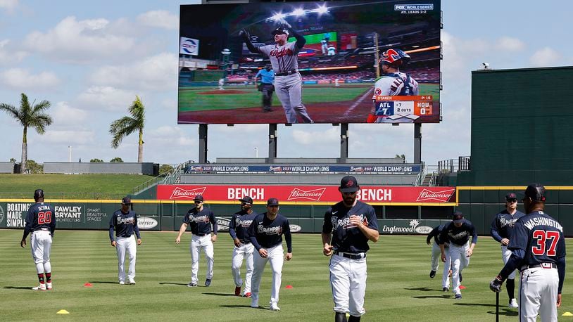 Braves first baseman Freddie Freeman is seen on the big screen rounding the bases on his home run during game six of the World Series while Dansby Swanson and the Braves loosen up in CoolToday Park during the first day of team practice at Spring Training on Monday, March 14, 2022, in North Port.   “Curtis Compton / Curtis.Compton@ajc.com”`